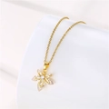 Détail macro du collier pendentif feuille avec zircons clairs sur chaîne dorée - Doré