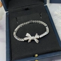 Elegant silver bow bracelet with zircons displayed in a navy blue velvet jewelry box - Silver
