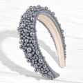 Detail view of a wide grey padded headband with dense faux pearls on a wooden texture background - Gray / US 13.5