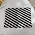 Close-up of black and white diagonal striped table mat with detailed stitching edge - Black Stripe