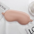 Pink satin silk sleep eye mask with wide elastic strap on white textured background - Nude
