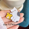 Detailed close-up of a 3.7x4.0cm white cat enamel pin held in hand showing dimensions - Cat and Mouse Pair