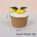 Artificial mango cupcake decoration with white cream and green leaves in a paper cup - Kraft Paper Mango
