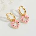 Detailed macro view of heart earrings with colorful zircon stones on white lace background - Pink