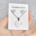 Detailed view of silver stainless steel jewelry set featuring double heart necklace and studs - Double Heart
