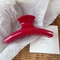 Detail of red large arc hair claw clip on white paper with a handwritten aesthetic card - Bright Red