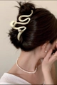 Detail view of a beige wavy hair claw clip with pearl accents on a bun hairstyle - 12cm / Off White