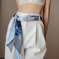 Blue vintage print silk scarf worn as a decorative belt on white high-waisted trousers - Diagonal Satin Scarf - Blue Chain and Leaves