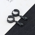 Detail of punk style black titanium steel hoop earrings with unique hand pendant charms - Hand - Black