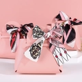 Pink faux leather wedding favor bags with decorative ribbon bows and elegant handles - Pink