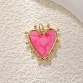Macro shot of gold-plated heart pendant with pink marble texture and gold bead accents - Gold Rose Red Marble Heart