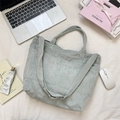 Vista superior de bolso tote de pana con correa ajustable y bolsillo frontal en escritorio - Verde Menta