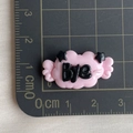 Detailed close-up of a pink resin cloud charm with BYE lettering and size scale - Pink Base Black BYE