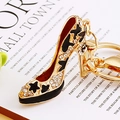 Golden high heel keychain with black enamel, stars, and sparkling white rhinestones - Black Star High Heels