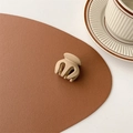Close-up of a matte beige hair claw clip placed on a brown leather texture surface - Matte Brown (Medium Approx. 3.5cm)