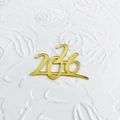 Nahaufnahme der goldenen Acryl 2036 Kuchendekoration mit Glanz auf floralem Untergrund - 2026 Goldener Spiegel