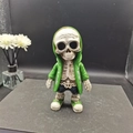 Detail der Skelett-Alien-Figur mit grünem Hoodie und Sneakern für die Gartendeko - Smaragdgrün