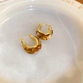 Vue rapprochée des boucles d'oreilles en résine ambrée en U avec bords dorés - Ambre/Or