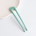 Minimalist U-shaped matte mint green hair pin placed on white ceramic plate - Green