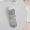 Graue Strick-Stulpen mit Rippenmuster, flach liegend in minimalistischem Stil präsentiert - Verpackte Schlanke Streifen / Hellgrau
