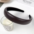 Dark brown PU leather padded headband with wide sponge design for women on a white desk - Brown