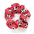 Red satin scrunchie with football patterns shown on white background in top view - Red