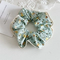 Detail van bloemen scrunchie in mintgroen met gehaakte kant op houten achtergrond - Groen Met Kant Rand