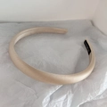 Detail view of a handmade beige satin headband with high-gloss texture on white background - Beige