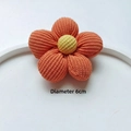Close-up of a 6cm orange knitted flower accessory with yellow center and ribbed texture - Original Version / 5-Petal Orange