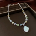 Dettaglio della collana di perle con ciondolo buddha verde chiaro e zirconi - Argento