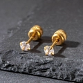Dettaglio macro di orecchini a lobo in oro con zircone da 3mm e chiusura a vite su ardesia - 3mm / Oro