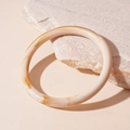 Detailed macro view of beige marbled acrylic resin bangle on a natural stone base - Rice White Round Style (20#)