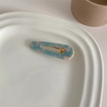 Detailed close-up of marble pattern acetate hair clip on a white ceramic tray - Blue Marble Water Drop