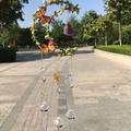 Detail of moon-shaped crystal wind chime with butterflies and prism ball in sunlight - Gold Green Leaf - Amethyst