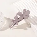 Detailed view of a matte purple double butterfly hair clip on a wavy display stand - Double Butterfly Clip - Matte Mocha