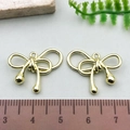 Golden metal bow pendants for DIY jewelry with 2.5cm scale measurement reference - Twisted Bowknot - KC Gold (21404)