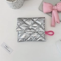 Close-up of a silver quilted makeup pouch with snap closure on a clean white desk - Diamond Quilted Silver Square Sanitary Pad Bag