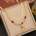 Detailed view of gold layered necklace with Hamsa hand and blue evil eye charm - 5# Palm Necklace