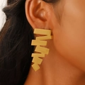 Orecchini a foglia dorati con trama opaca spazzolata indossati da una modella - Stile Lungo Seghettato Geometrico (N-136) / Oro