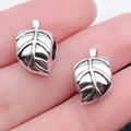 Pair of antique silver leaf charms for DIY bracelets shown on a palm for scale - 1pc Leaf Large Hole Bead