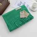 Grass green cashmere-style scarf with fringe and brand labels on a minimalist tabletop - Vibrant Green / 200cm