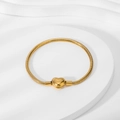 Detail of 18K gold snake chain bracelet featuring a heart-shaped clasp on white stand - Gold Heart Clasp