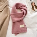 Detail showing pink knitted scarf with 'emo' fabric label on white textured background - Ice Pink