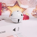 Primo piano di una campana di Natale in metallo bianco con stelle su un libro - Bianco