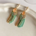 Detailansicht der Boho-Goldohrringe mit orangefarbenen Edelsteinen und Türkisquasten - Ohrhaken - Grün