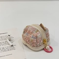 Vista dettagliata della custodia AirPods in tweed rosa con elegante ciondolo in perla - Rosa