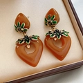 Vue détaillée des boucles d'oreilles cœur vintage en résine ambrée avec fleur dorée - Tige en argent 925 / Ambre
