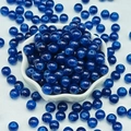 Macro detail of translucent dark blue chalcedony glass beads in a white ceramic petal bowl - 4mm / Sapphire Blue