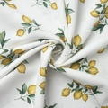 Detailed view of white floral fabric featuring realistic lemon and leaf patterns - Lemon Print White