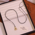Goldene Geldbeutel-Halskette mit Dollar-Symbol auf elegantem Schmucktablett - Lanyard-Stil / Gold